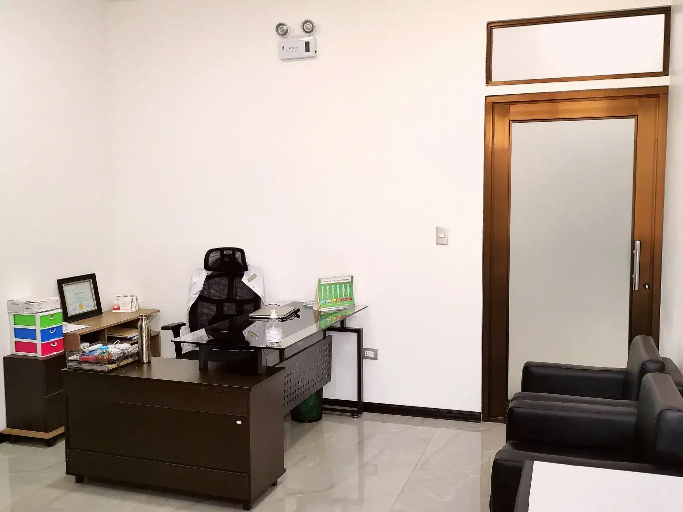 Consultorio médico de 16m² con mobiliario moderno, internet y aire acondicionado.