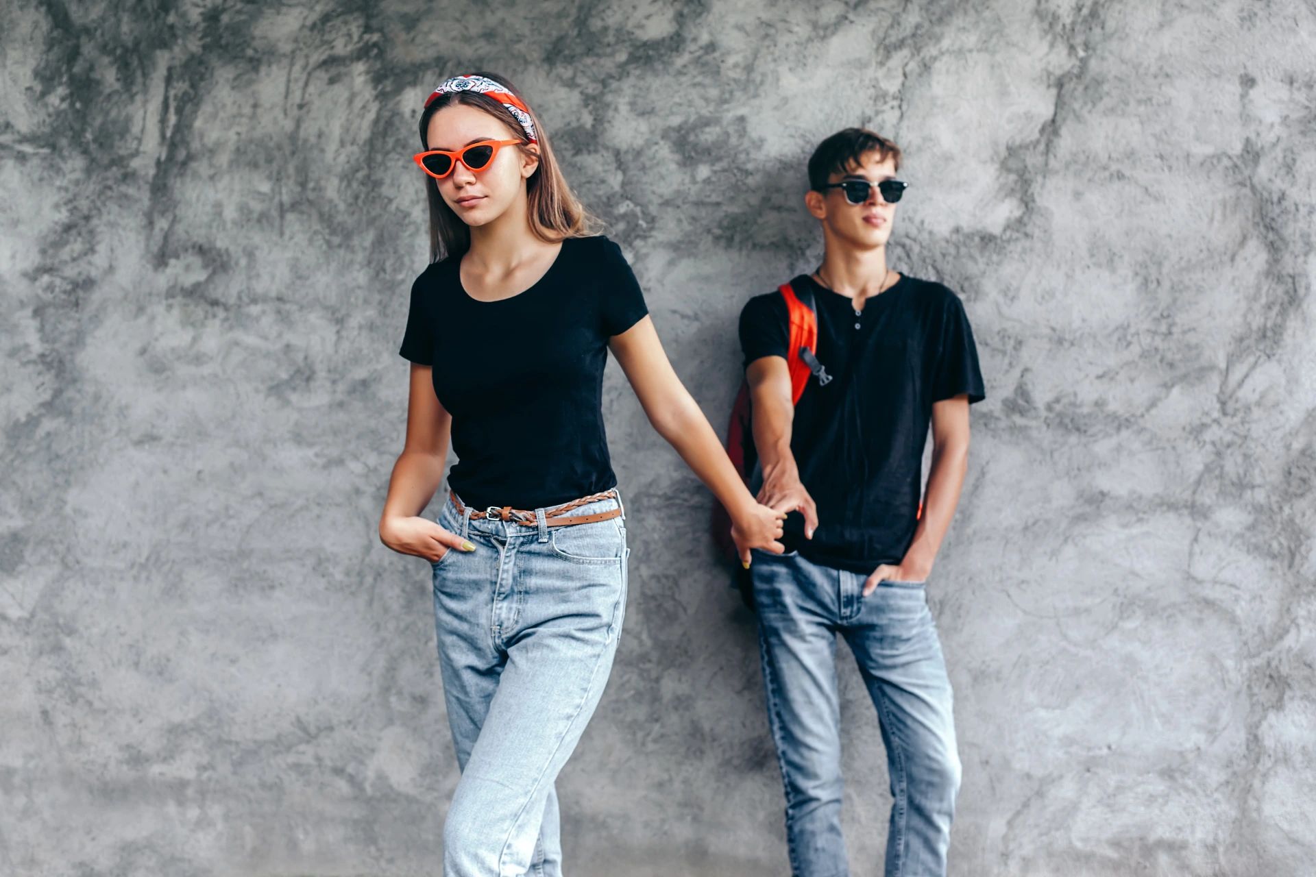 Pareja de adolescentes con piel sana y sin acné, vistiendo ropa casual y lentes de sol.