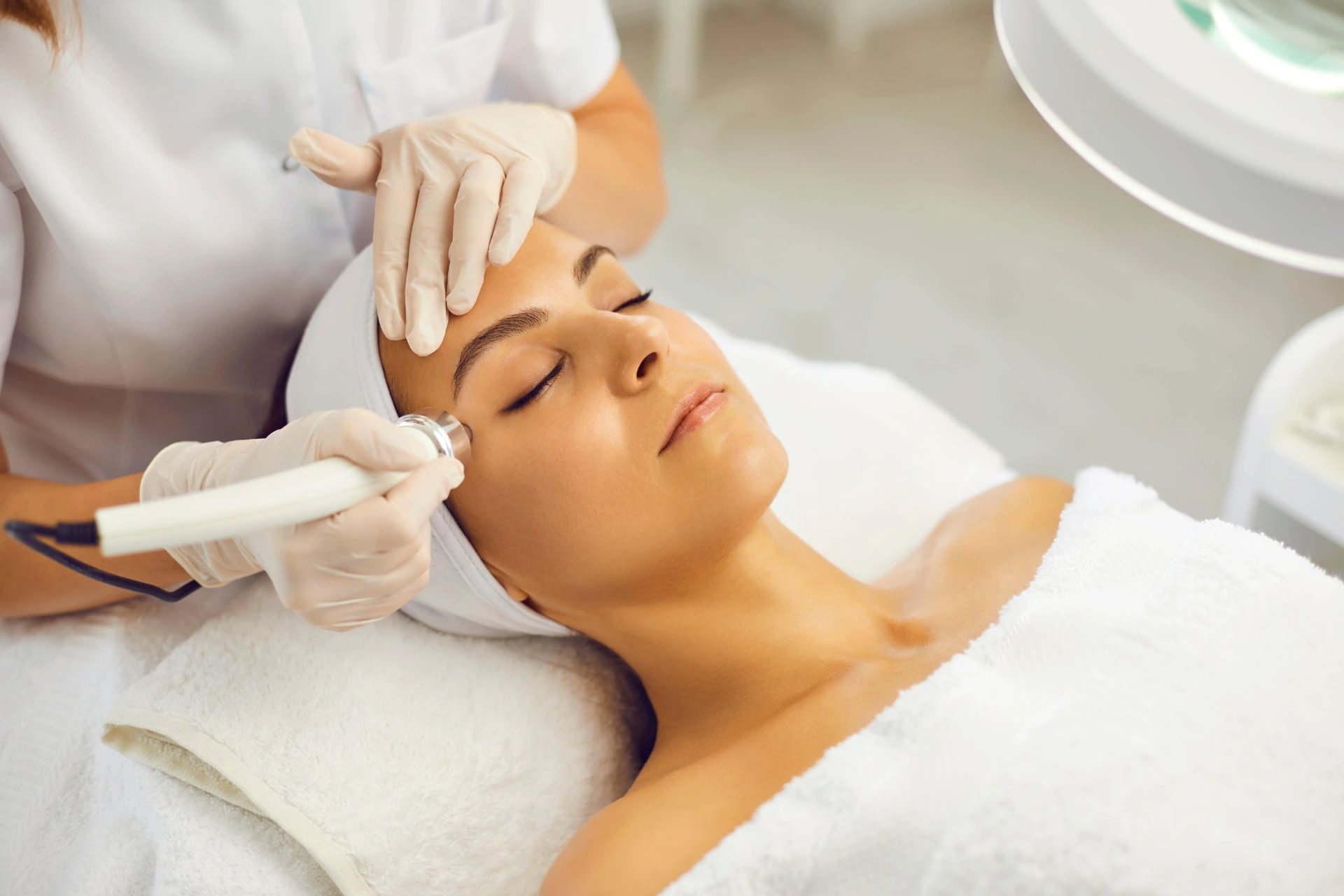 Mujer recibiendo un tratamiento de Peeling Láser Fotona en un centro estético, con piel radiante y relajada.